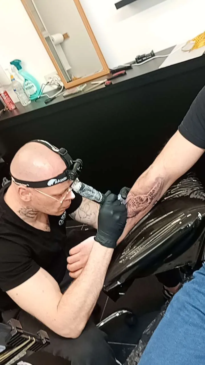 Robert Grzywacz tattooing in the studio